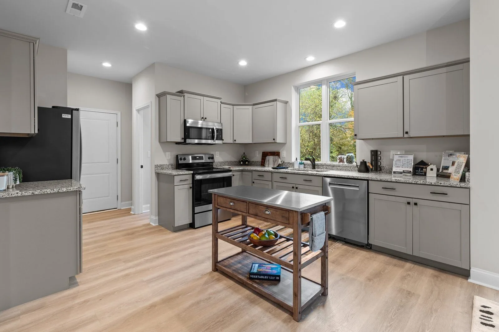 Open living and dining interior with soft seating, artwork, and a view of the kitchen.
