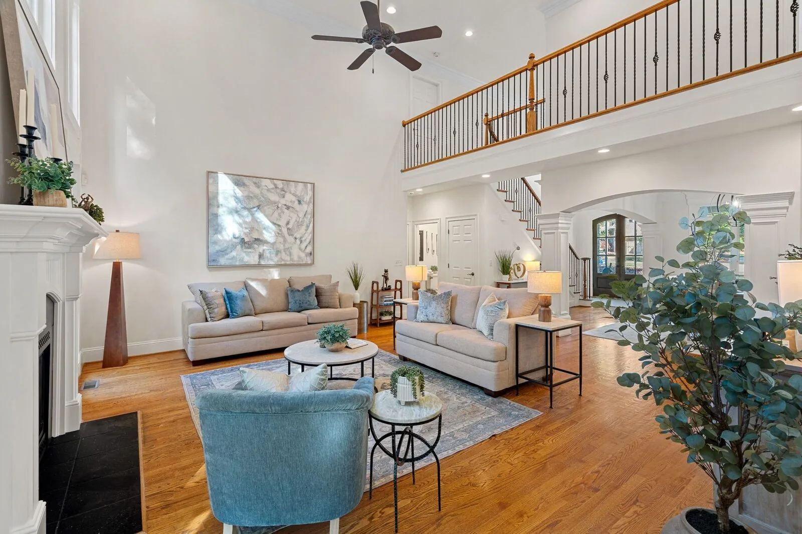 Staged living room with sofas, a blue accent chair, and a fireplace.